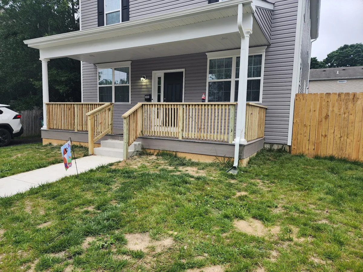 Custom wood porch railing with fence in background