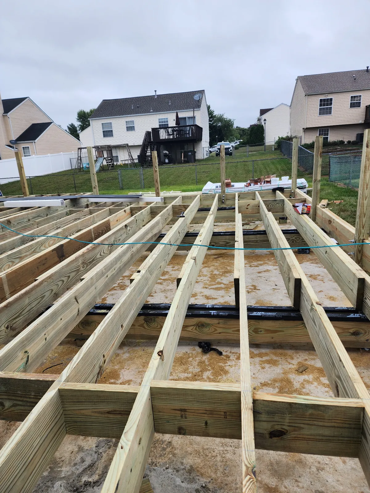 Pressure-treated wood deck joists and framing under construction
